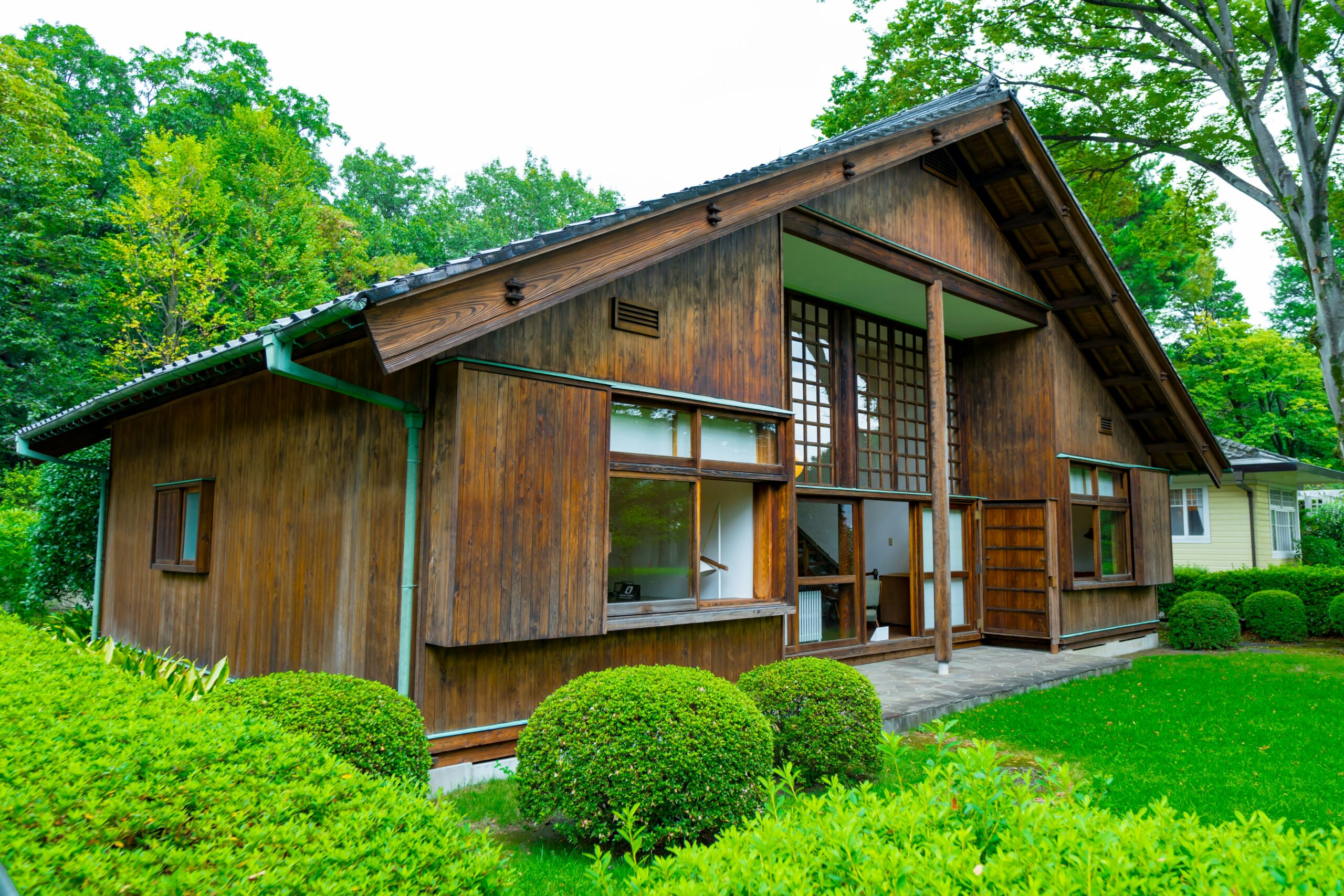 a small wooden house with a green lawn